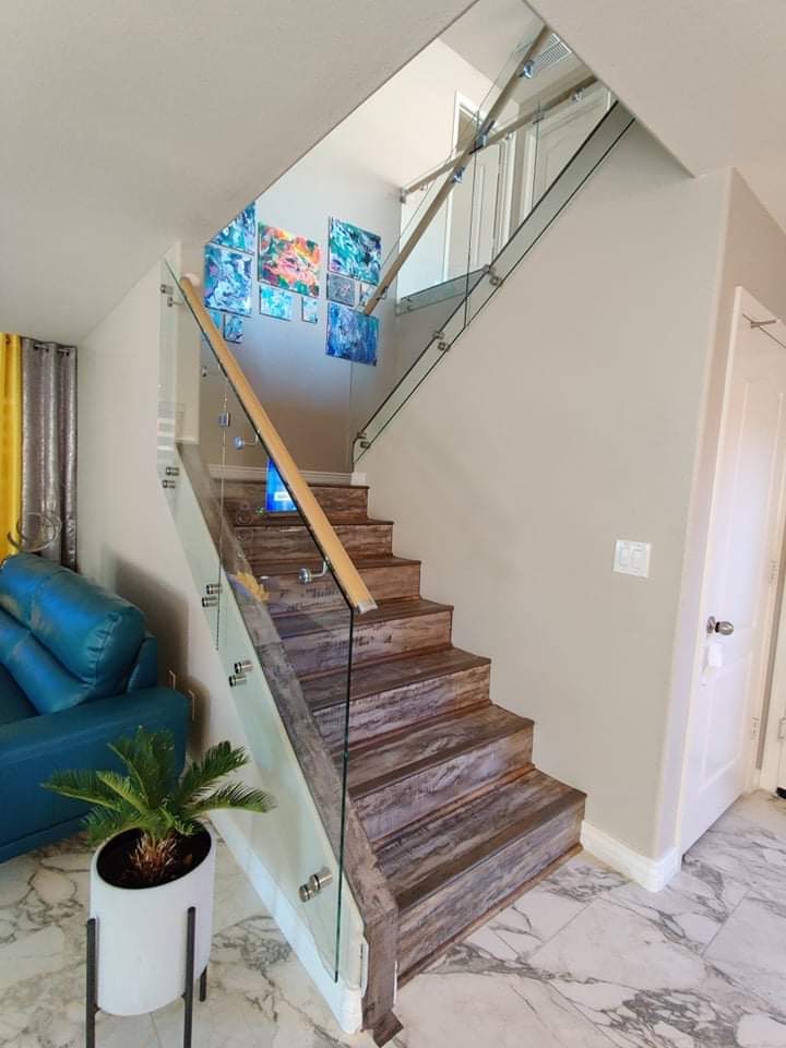Glass stair railing with wood handrail and standoff hardware